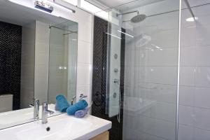 a bathroom with a sink and a glass shower at Studioapartment Borinquen in Playa Fañabe +15 photos