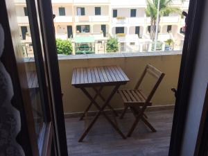 a wooden table and a chair on a balcony at B&B PESCIOLINO ROSSO in Gallipoli