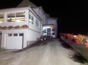 a white house with a garage at night at Karavan 123 in Raška