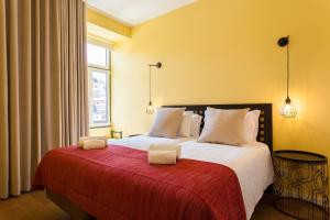 a bedroom with a large bed with a red blanket at ALTIDO Sublime 2BR Apt on Restauradores Square nearby Rossio Station in Lisbon