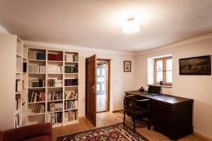 a home office with a desk and book shelves at Landhaus Holzen in Pfarrkirchen