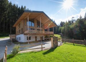 a house with a wooden roof on top of a field at Schladminger Tauern Apartment in Haus im Ennstal