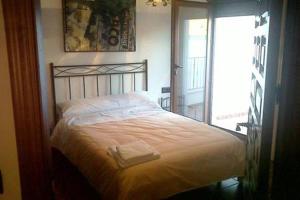 1 dormitorio con 1 cama grande y ventana en Casa Rural Trastámara, en Montiel