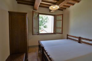 a bedroom with a bed and a window at Agriturismo Il Beccafico Alpaca in Mengara