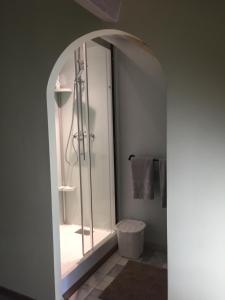uma casa de banho com um chuveiro e uma porta de vidro em Tess Cottage em Brie-sous-Mortagne