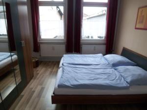 リューネブルクにあるFerienwohnung am Liebesgrundの窓2つが備わるドミトリールームのベッド1台分です。