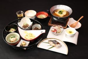 einen Tisch mit verschiedenen Lebensmitteln auf Platten in der Unterkunft Hakone Yuyado Zen in Hakone