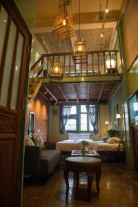 a living room with a loft with a bed and a table at Live Local Cafe & Hotel - 420 Friendly in Bangkok