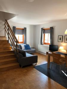 ein Wohnzimmer mit einer Treppe und einer Couch in der Unterkunft Apartments Rombon in Bovec