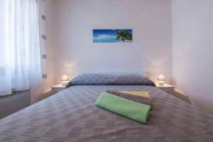 a bedroom with a bed with a green pillow on it at Apartment Dendy in Pula