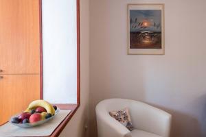 a bowl of fruit on a table next to a chair at Apartment Dendy in Pula