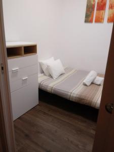 a small bedroom with a bed and a dresser at NiM Eixample 5 in Barcelona