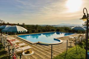 a large swimming pool with chairs and umbrellas at Agriturismo Malagronda in Ravigliano