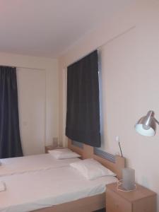 - une chambre avec 2 lits et une fenêtre dans l'établissement ZAGA Apartments, à Koroni