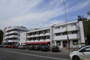 a large white building with cars parked in front of it at Hotel Europolis in Tulcea