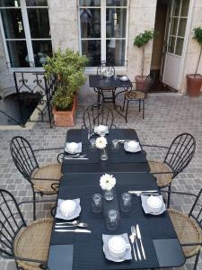 
a dining room table with chairs and plates of food at Hotel La Closeraie in Sully-sur-Loire
