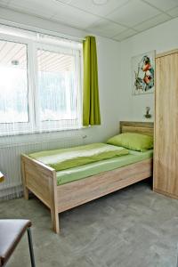 a bedroom with a wooden bed in a room at Pension Waldesruh in Linz