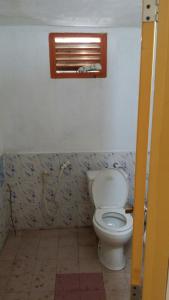 a bathroom with a toilet and a window at The Forest Villa in Weligama