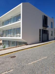 un edificio blanco con una calle delante en Casa Praia Mar, en Salema