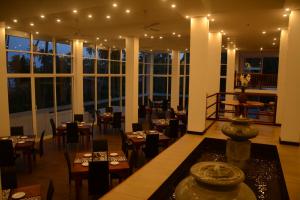 un restaurante con mesas, sillas y ventanas grandes en Sole Luna Resort & Spa, en Tangalle