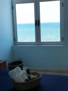 um quarto com duas cestas numa cama com vista para o oceano em Casa Natali em Durrës