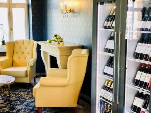 a room with two chairs and a refrigerator with wine bottles at Hotel am Bayrischen Platz in Leipzig