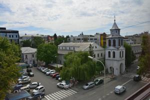 a street with cars parked in a parking lot next to a church at Hotel Europolis in Tulcea