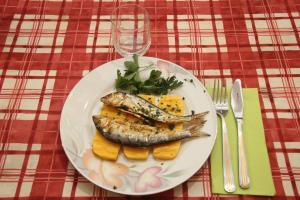 un plato de pescado y fruta en una mesa en Foresteria La Ceriola, en Monte Isola