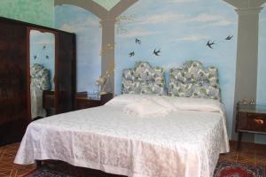 a bedroom with a white bed with birds on the wall at Foresteria La Ceriola in Monte Isola