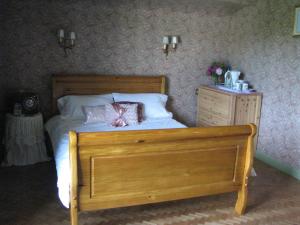 TreignacにあるChambre d'hôtes des Monédièresのベッドルーム1室(木製ベッド1台、木製ドレッサー付)