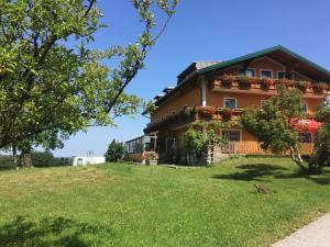 una casa en una colina con un patio verde en Pension David, en Puch bei Hallein