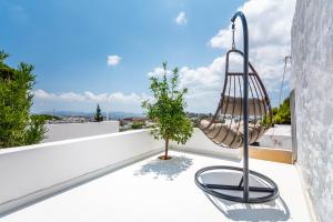 a swing on the balcony of a house at Plaka Suites in Plaka Milou