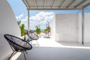 a patio with two chairs and a table on a building at Plaka Suites in Plaka Milou