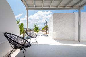 a patio area with chairs, a table and a window at Plaka Suites in Plaka Milou