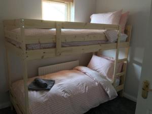 2 stapelbedden in een kamer met een bed bij Family home sleeps 6 plenty of parking in Portrush