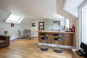 a kitchen and living room with a counter and stools at Socair in Callander
