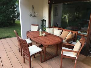 een houten tafel en stoelen op een terras bij Schlosspark Bungalow in Seebenstein