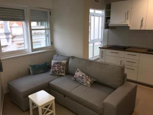 a living room with a couch and a kitchen at Rua Conselheiro Bivar in Faro