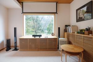 a living room with a large window and a table at Condominium Sakura in Hakone