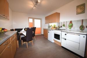 a kitchen with white cabinets and a table and chairs at Wegscheiderhof in Mühltal