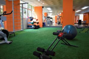 un gimnasio con alfombra verde y un gimnasio con equipamiento en Realminas Hotel e Restaurante, en Governador Valadares