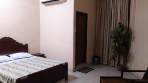 a bedroom with a bed and a plant in it at Saj Rest' inn in Kannur