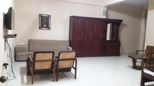 a living room with a couch and a table and chairs at Saj Rest' inn in Kannur