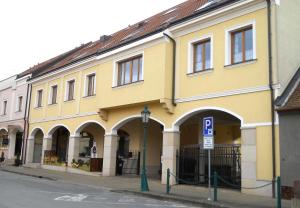 um edifício amarelo com um sinal de estacionamento numa rua em Apartmán Lednice em Lednice