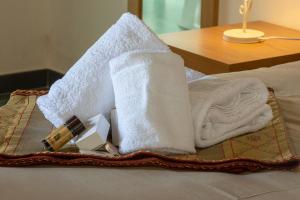 uma pilha de toalhas e produtos de higiene pessoal numa cama em Antico Resort Cerasella em Petralia Soprana