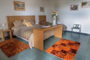Un dormitorio con una cama y una mesa con flores. en Antico Resort Cerasella, en Petralia Soprana