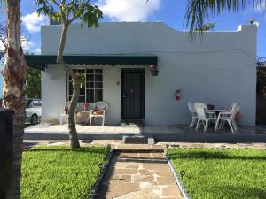 a white house with a patio and a table and chairs at Close to Everything Miami in Miami