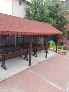 a picnic shelter with two benches and a playground at Vila Dan in Costinesti