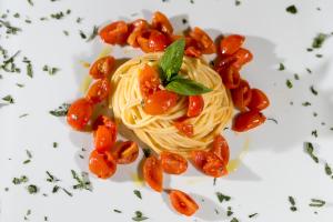 a white plate topped with pasta and vegetables at Millennium Gold Hotel in Naples