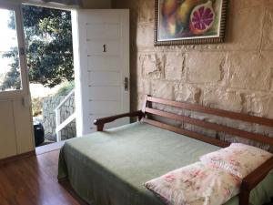 1 dormitorio con 1 cama y puerta con ventana en Casa da Nona, en Gramado